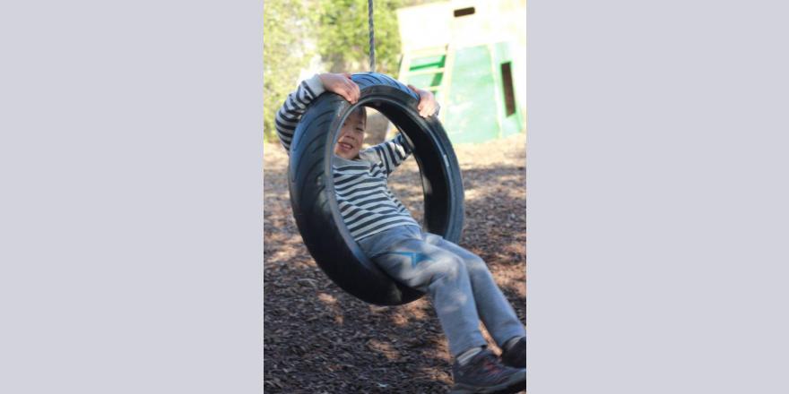 Boy in tyre swing at Annabel's Avonhead preschool