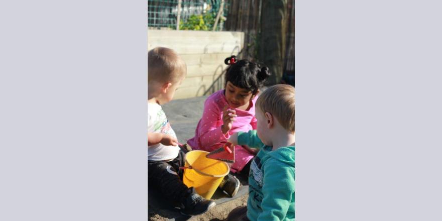 Kids playing with bucket of sand at Annabel's Avonhead preschool