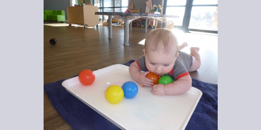Infant playing with balls at preschool