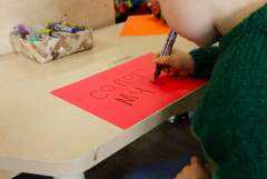 a child drawing and writing at preschool compressed